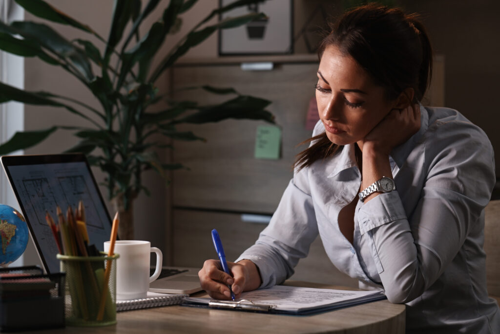 HR professional attentively working at a computer, surrounded by charts and notes on employee retention strategies