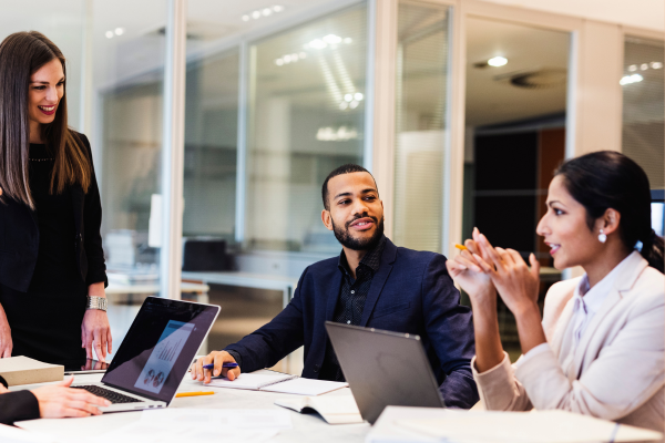 Diverse group of men and women collaborating in an office, representing inclusive HR trends.