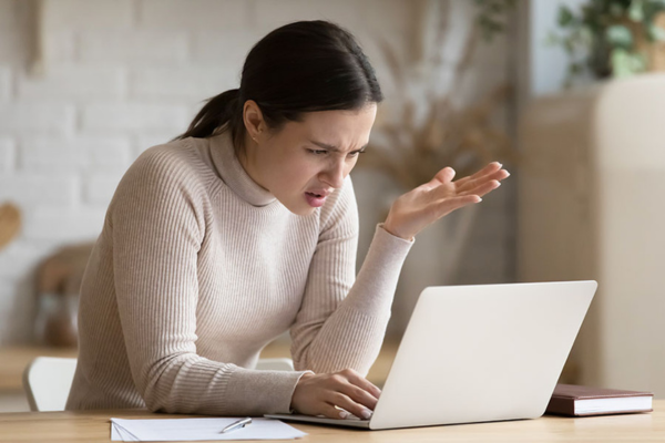 Frustrated person looking at a laptop, confused by ghost job postings.