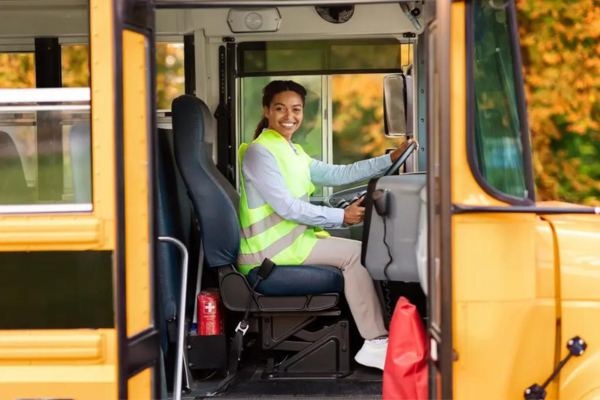 Happy school bus driver, highlighting retention in bus driver recruitment.