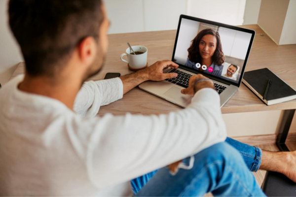 Person engaging in a virtual therapy session via video call on a laptop.