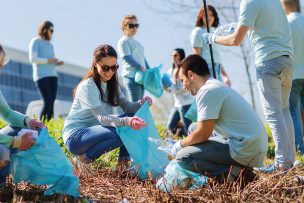 Employees participating in a company CSR activity, collecting waste as part of a community environmental sustainability project.