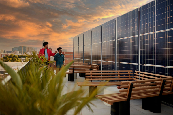 Young professionals inspecting solar panels on a rooftop as part of seasonal recruitment.