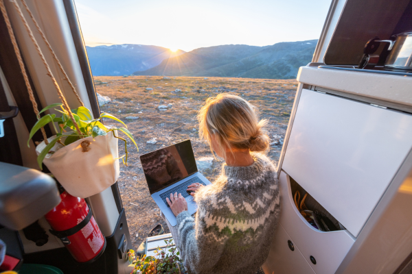 A remote worker using a laptop outdoors, illustrating flexibility in seasonal recruitment.