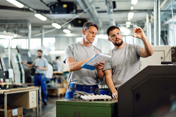 Light industrial workers collaborating in a manufacturing facility.