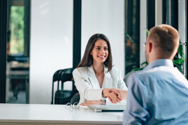 Hiring manager shaking hands with a candidate, demonstrating the importance of a positive candidate experience.