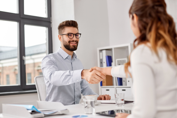 A recruiter and candidate shaking hands, symbolizing a successful match between the candidate’s career goals and recruiter expertise.