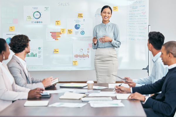 A business professional leading a meeting focused on employee upskilling and development strategies.